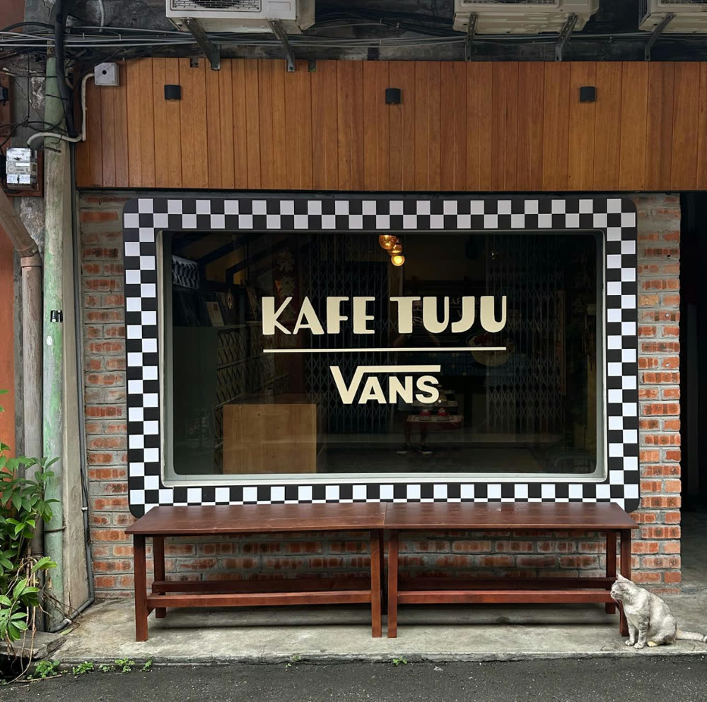 Kafe Tuju and Vans checkerboard shopfront with a bench outside
